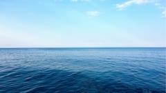 Billig hanterad hemsida med havsutsikt Vy över stilla blått hav och ljusblå himmel